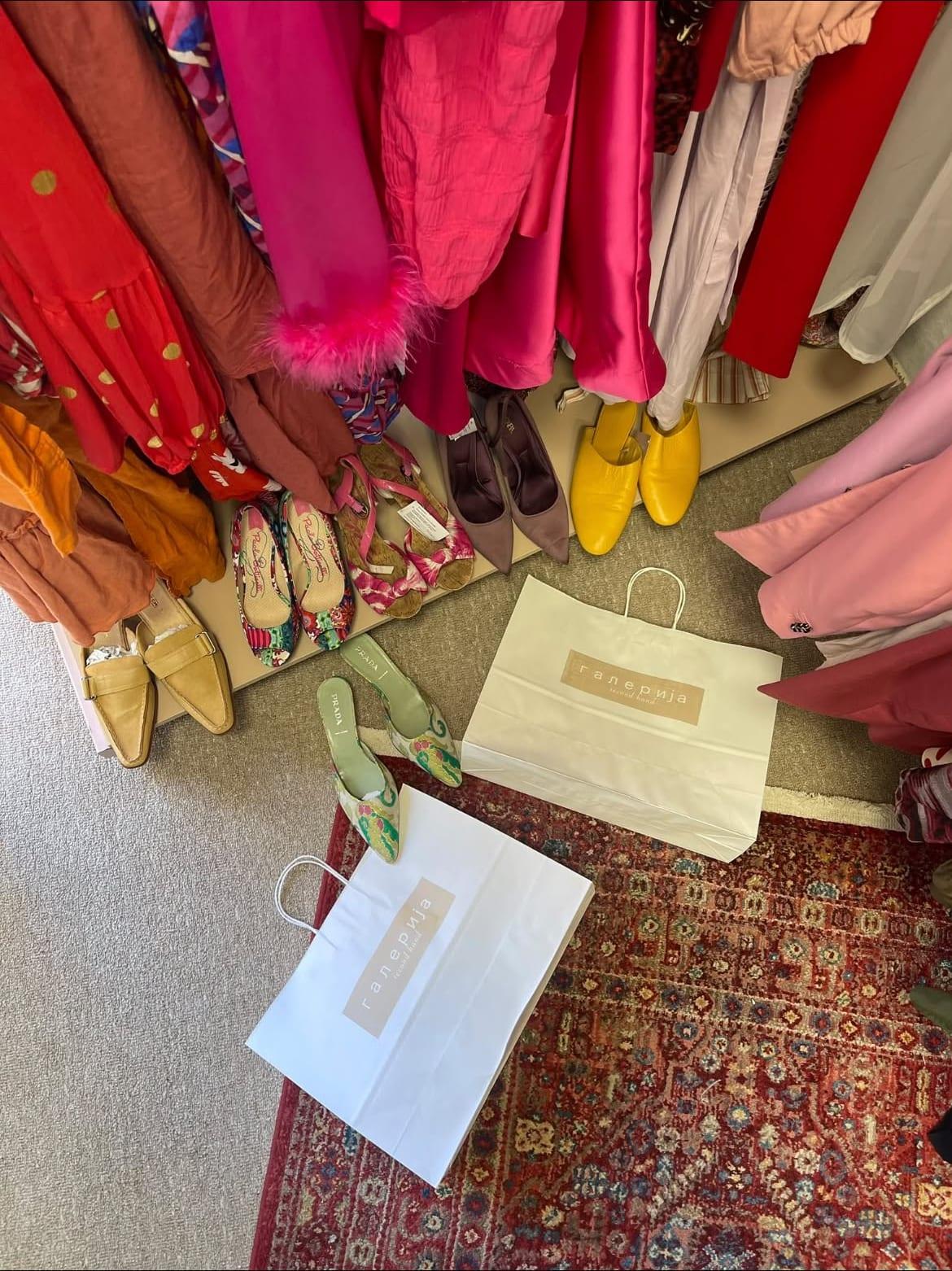 galerija branded shopping bags and shoes arranged on a patterned rug.