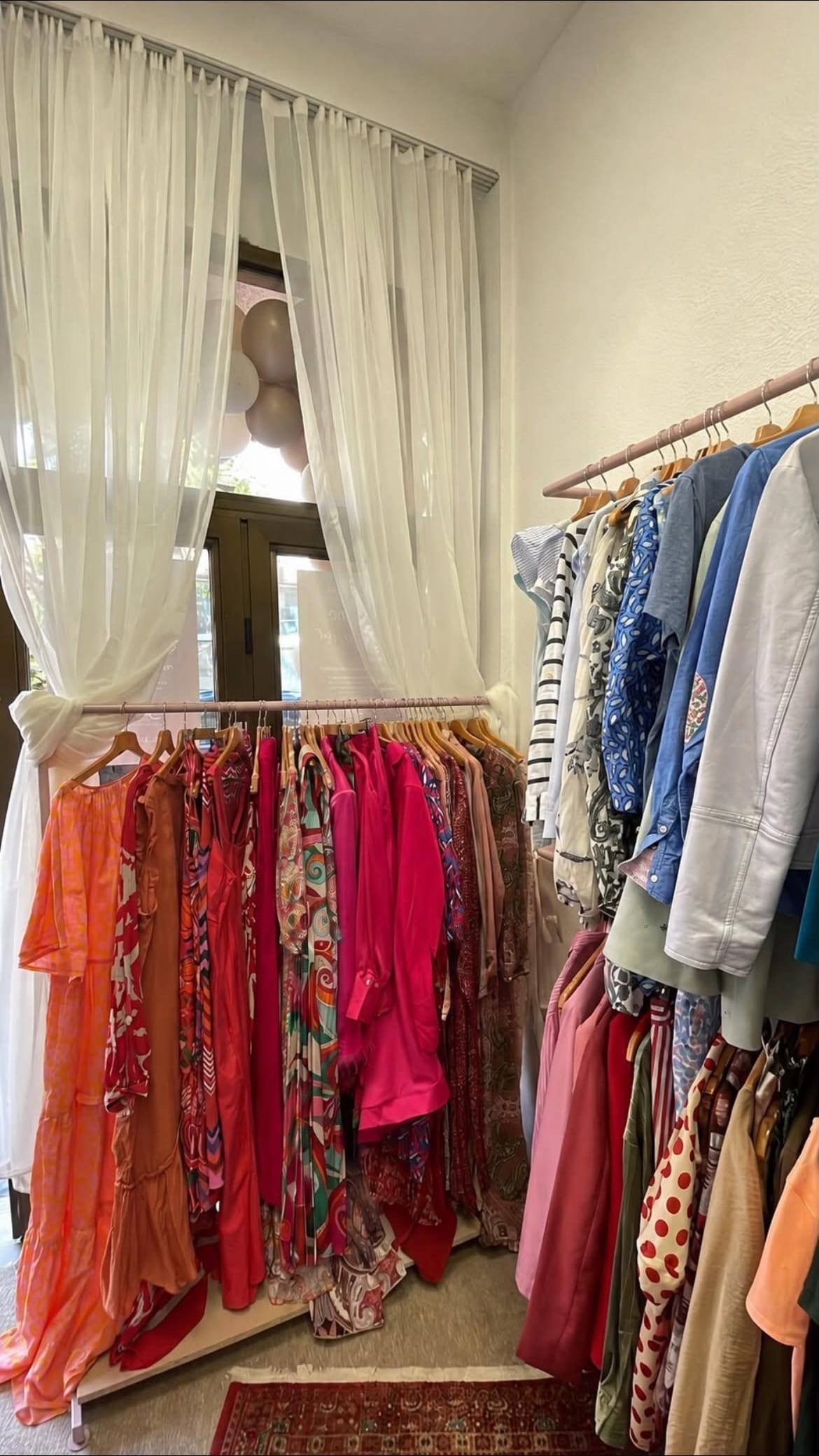 Sheer curtains and racks of colourful clothing in a corner of the galerija boutique.